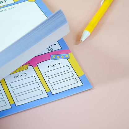 Colorful ADHD A5 brain dump notepad, zoomed in on "Next 3" list with a pen on a light pink background