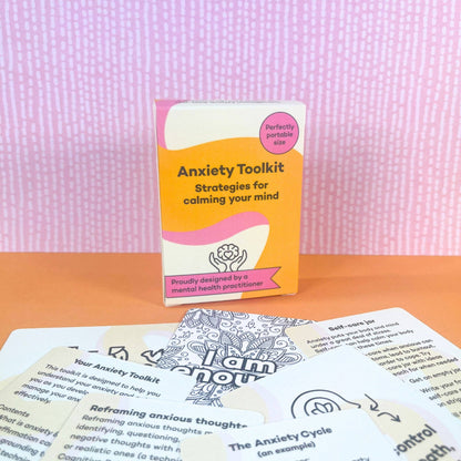 ADHD mental health anxiety toolkit surrounded by printed cards on a pink textured background