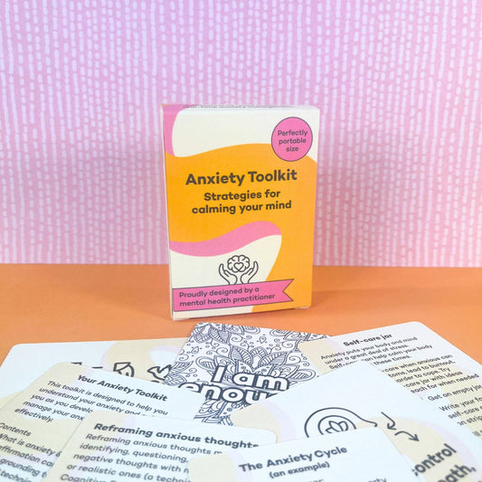 ADHD mental health anxiety toolkit surrounded by printed cards on a pink textured background
