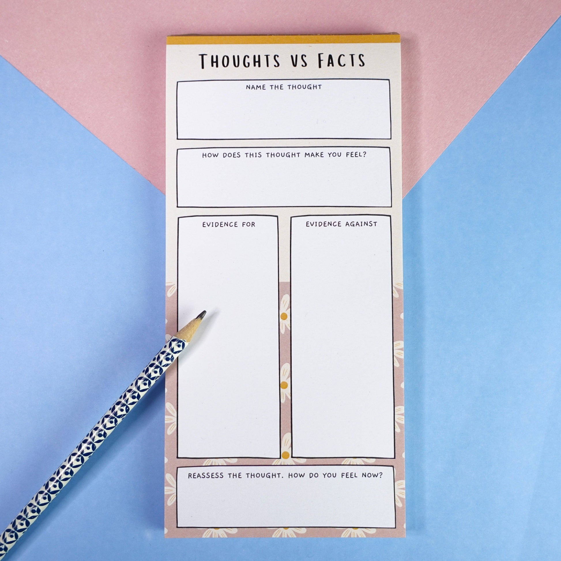 ADHD thoughts vs facts notepad with on a pink and blue background and a patterned pencil