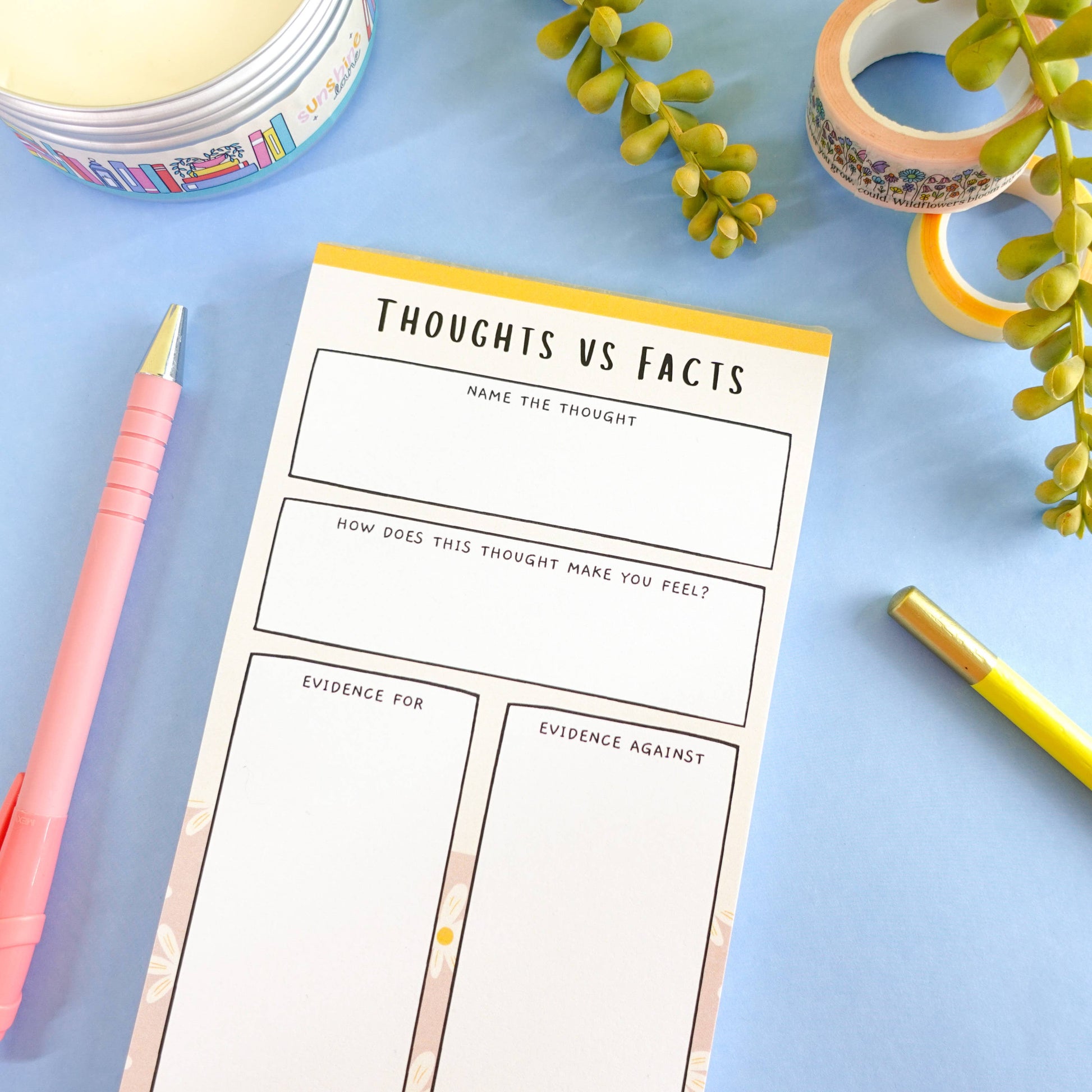 ADHD thoughts vs facts notepad on a blue surface with stationery items and washi tape